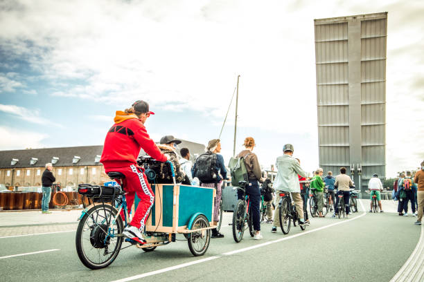 People cueing with bicycles and Christiania bikes in front of the Butterfly 3-Way Bridge, the famous foot bridge in Copenhagen.
