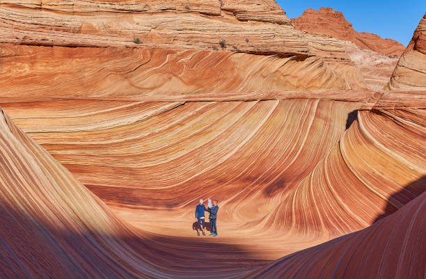 Father, Mother, and Toddler Daughter Exploring The Famous Wave of Coyote Buttes North in the Paria Canyon-Vermilion Cliffs Wilderness of the Colorado Plateau in Southern Utah and Northern Arizona USA Father, mother, and toddler daughter exploring the famous Wave of Coyote Buttes North in the Paria Canyon-Vermilion Cliffs Wilderness of the Colorado Plateau in southern Utah and northern Arizona USA. the wave arizona stock pictures, royalty-free photos & images
