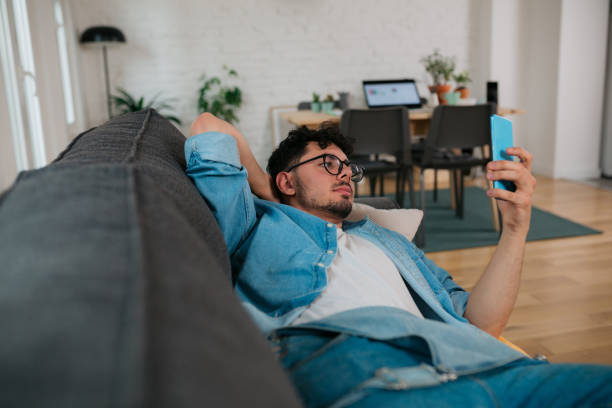 istock Young Caucasian man using a smart phone at home 1386052500