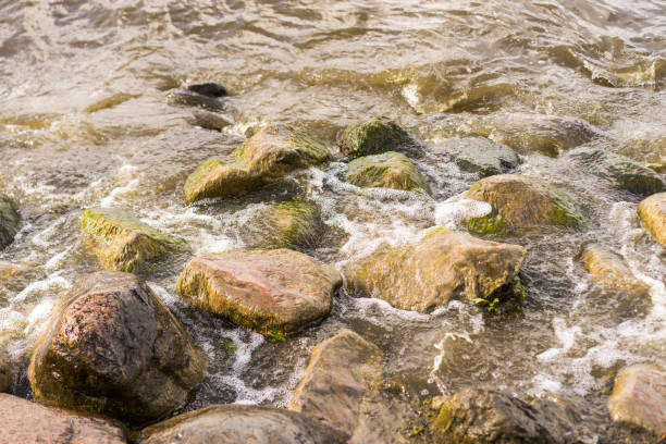 istock Sea stones and waves on the beach. Summer background. 1386053892