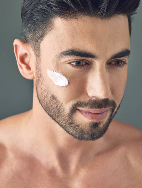 istock Studio shot of a handsome young man posing with moisturiser on his face 1386057185