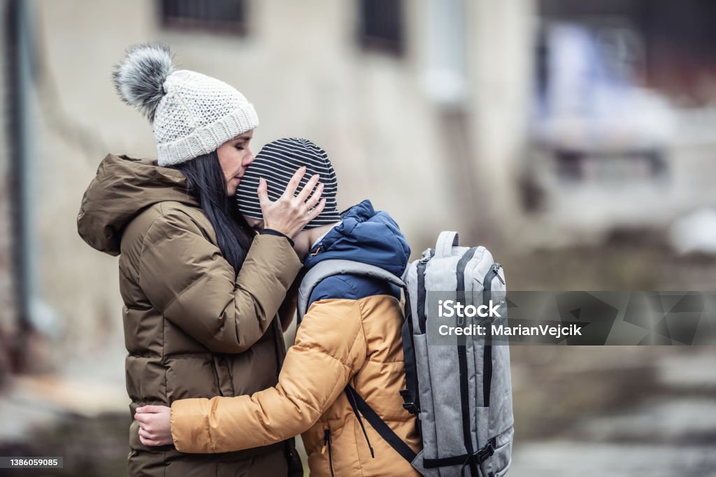 Woman kisses her boy Refugee Stock Photo