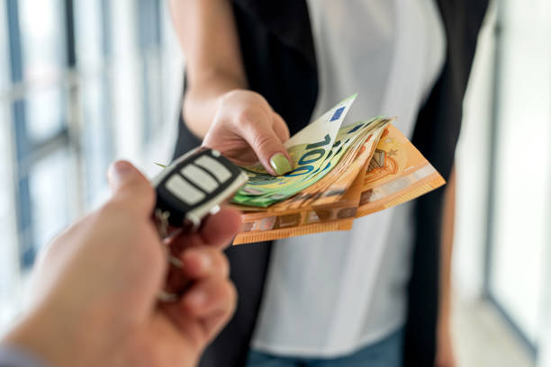 a young business woman is given car keys and she is euros for a car stock photo