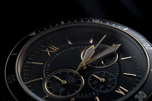 Close up of Black wrist watch with golden details