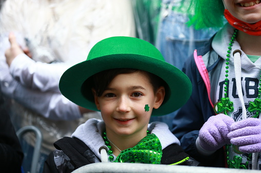 New York, New York - March 17, 2022: Crowds along Fifth Ave. are dressed fashionably green in clothing for the St. Patrick's Day Parade in New York.