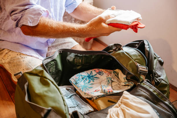istock Close up on man packing for a trip, puts clothes in a duffel bag 1386076069