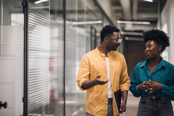 istock Casual chat between two business people in office hallway 1386076360