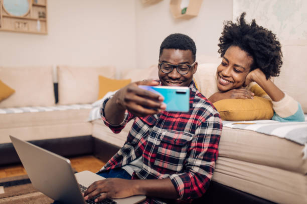 istock Young man taking a selfie with his girlfriend while freelancing 1386079119