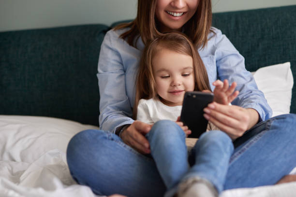 istock Mother and daughter using smartphone together 1386079449