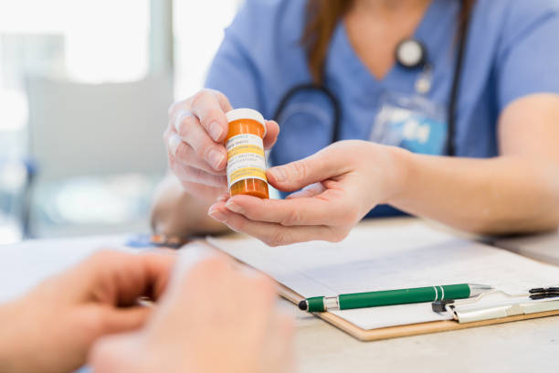 istock Close up of pill bottle held by unrecognizable doctor 1386085678