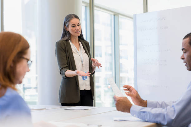 istock Female lawyer gestures as she explains documents to staff 1386085681
