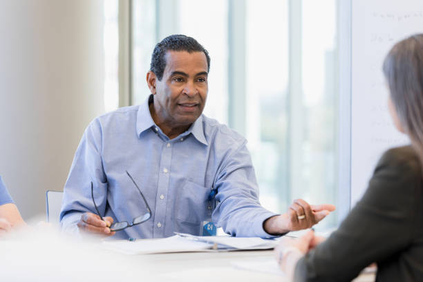 istock Serious man gestures and asks unrecognizable professional woman some questions 1386085697