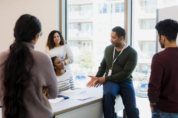 In a relaxed class session, mature professor interacts with students