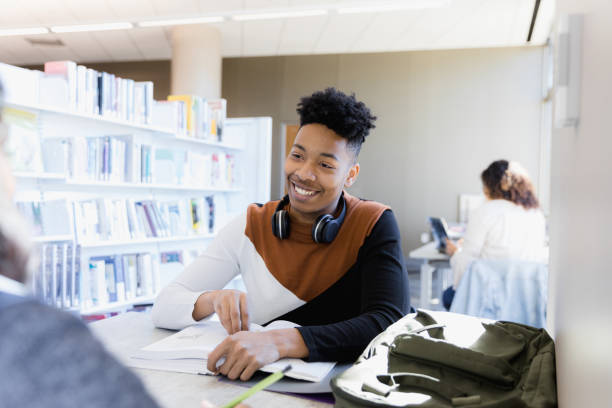 istock While studying together, young man smiles at unrecognizable girlfriend 1386085782