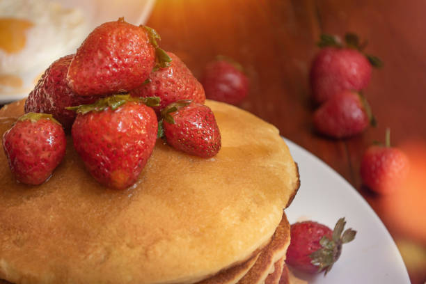 Plate of hot cakes and strawberries on a table stock photo