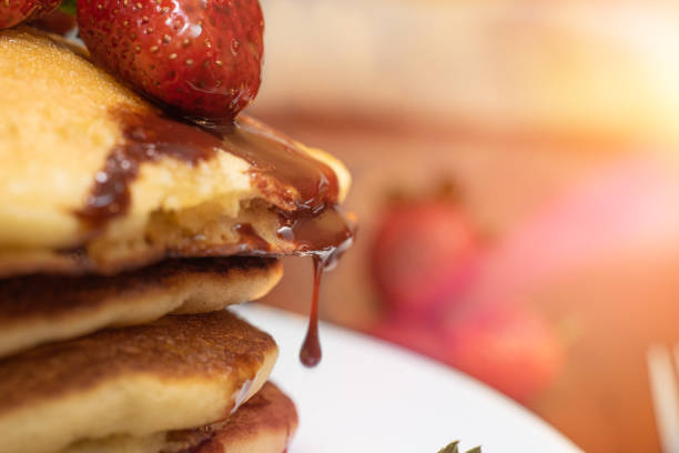 Closeup of a strawberry dripping chocolate syrup stock photo