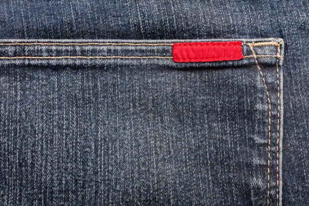 Texture backdrop photo of blue colored denim cloth with red label.