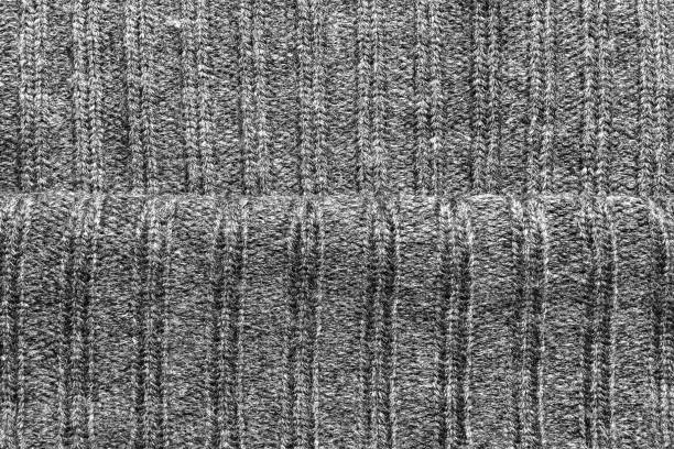 Texture backdrop photo of grey colored woold knitted fabric cloth folds.