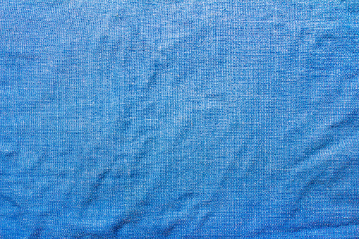 Texture backdrop photo of worn blue colored cotton cloth material.