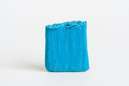 Blue dry soap with cracks on white isolated background