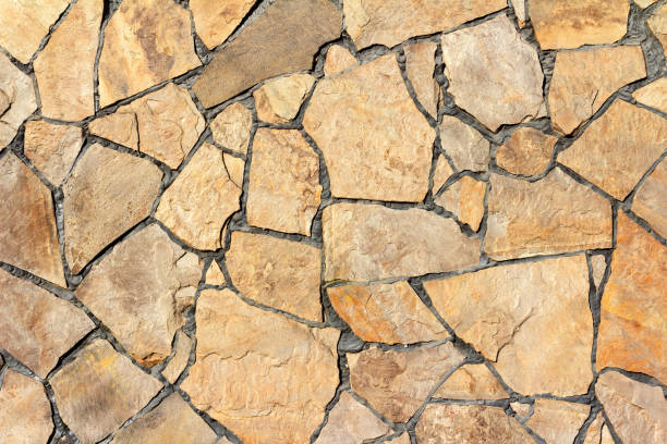 Photo texture of stone tile wall. Photo texture of brown colored stone wall tile. crazy paving stock pictures, royalty-free photos & images