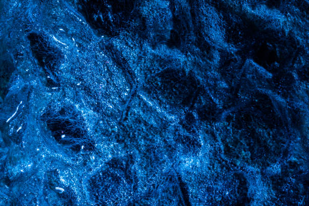 istock Dark blue toned wooden coal in ice. 1386100237