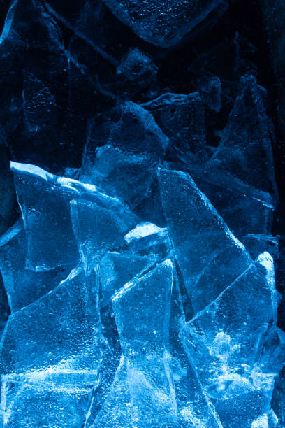 Blue toned frozen cracked ice pieces texture. stock photo