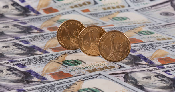 istock One hundred American dollar bills and one American dollar coins 1386105291