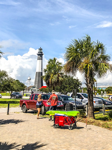 September 10, 2020, Tybee Island, Georgia.  The Tybee Island lighthouse stands in the background as people get ready for a day of fun on the beach and beside the Atlantic Ocean.