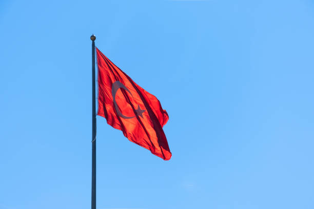 istock Turkish flag waving in the blue sky. Flagpole. 1386107858