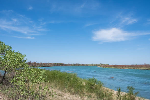 istock Ili river in spring time. Beautiful river with blue water and sky. Wild nature landscape background. 1386111111