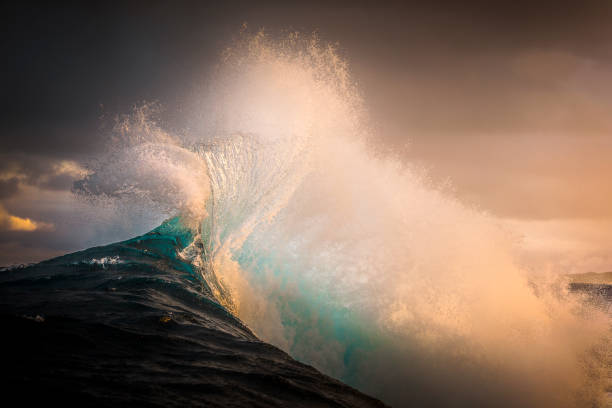 istock Majestic blue wave splashing into sky in golden afternoon light 1386131003