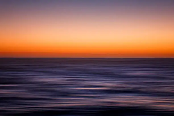 Photo of Abstract, vibrant-colored slow shutter of ocean horizon