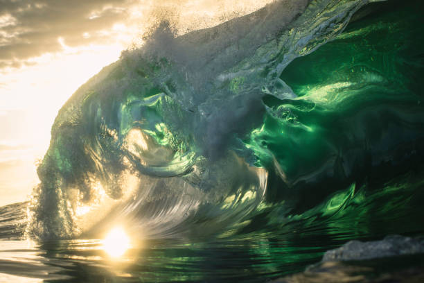 istock Beautiful teal green ocean wave crashing under golden light 1386134159