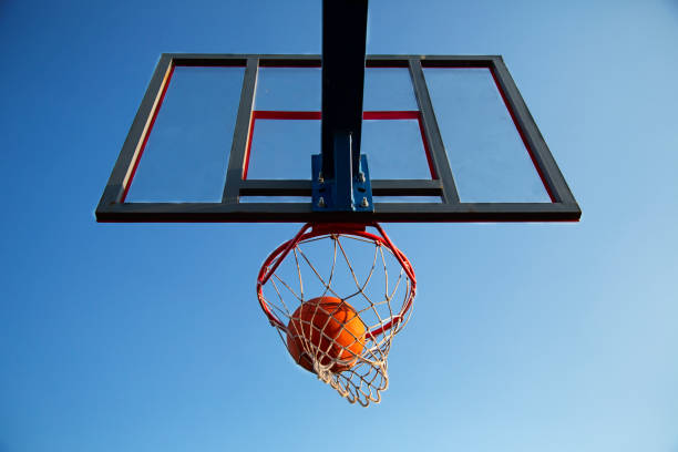 istock An orange basketball is flying through a basket. 1386148782