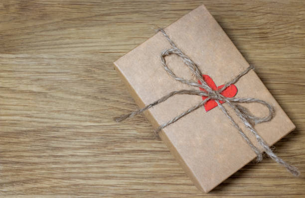 Gift with red heart on wooden background