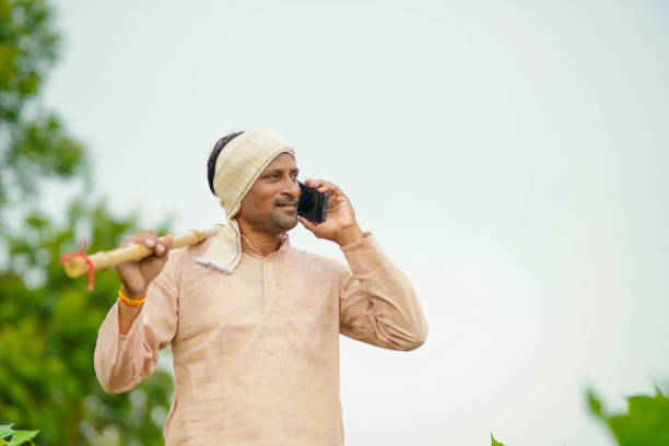 istock Indian farmer talking on mobile phone at Agriculture field 1386152552