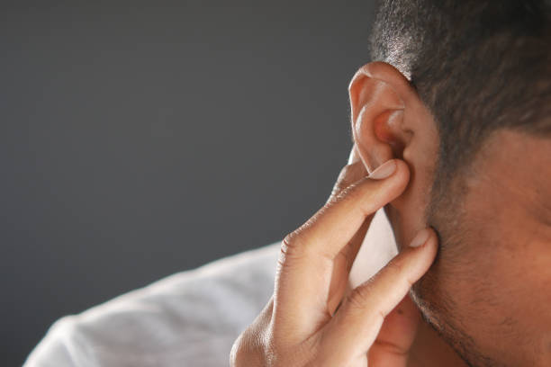 istock young man having ear pain touching his painful ear , 1386153370