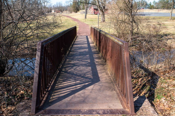 istock A bridge crosses a stream to a hiking trail through countryside 1386159800