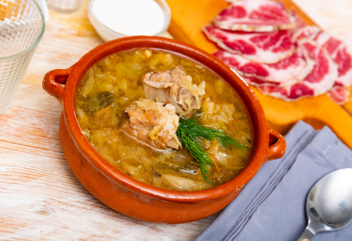 Russian cuisine. Popular national Shchi cooked from sauerkraut in mushroom broth with pork meat served with sour cream