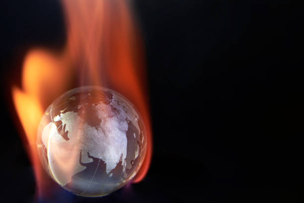 istock Glass planet earth on fire on black background, copy space. 1386164758