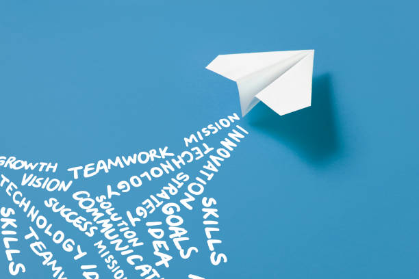 istock Paper Plane on  with Business Related Words on Blue Background 1386166086