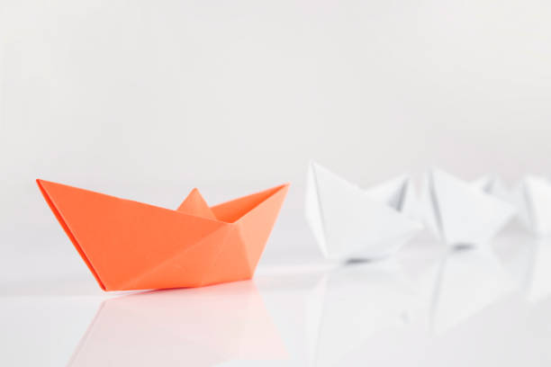 istock Leadership Concept with Orange Colored Paper Boat 1386166271