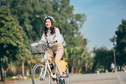 Asian woman renting shared bicycle in city centre  go to work at office