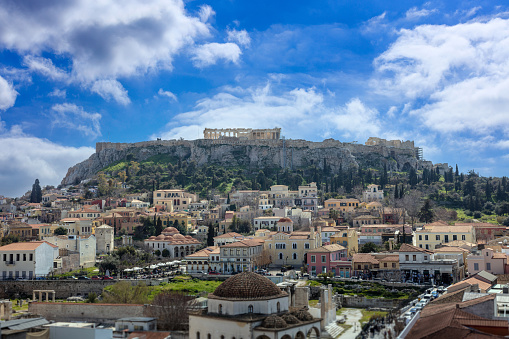Athens, Greece. Monastiraki square. Aerial view of the historic city and Acropolis rock. Parthenon temple on the top. Cloudy blue sky background