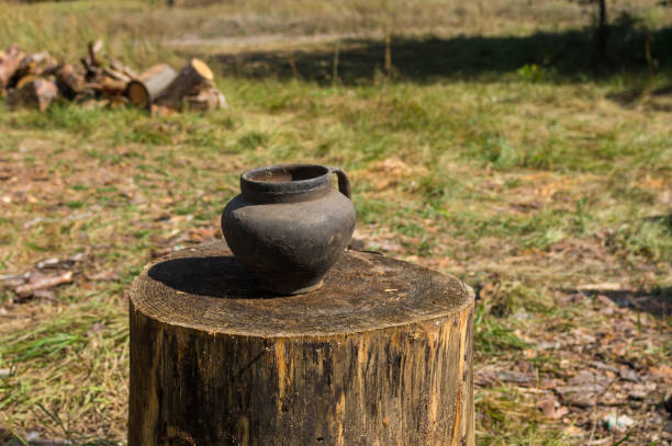 istock ancient  Ukrainian pot standing on a big log  at summer season 1386170638