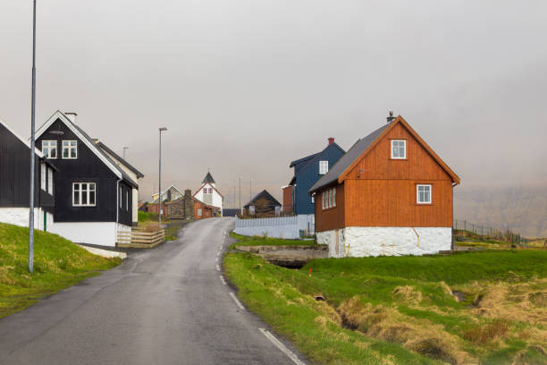 Scenic view of old town with colourful houses by the sea in green summer colours on Suduroy island, Faroe Islands