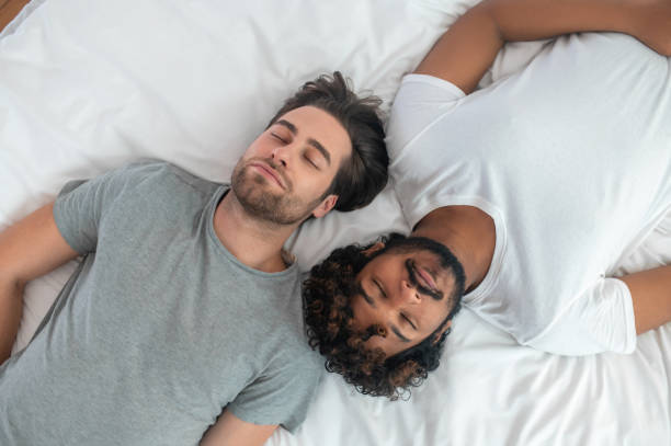 ベッドで仰向けに寝ている二人の若い男性 - sleeping lying on back couple bed ストックフォトと画像