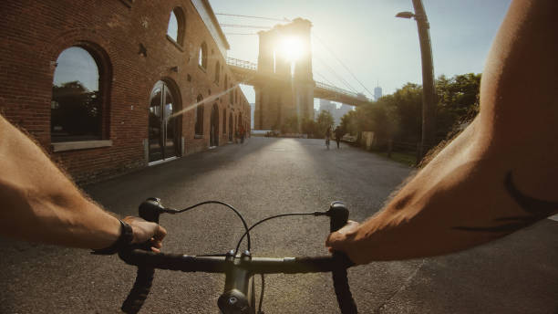 vacanze negli stati uniti: bicicletta da corsa su strada pov a dumbo, new york - brooklyn bridge movie famous place people foto e immagini stock