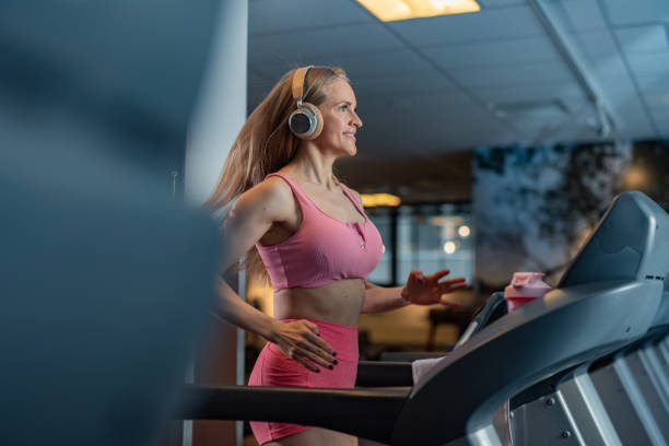 istock Woman jogging on treadmill in a gym 1386173688
